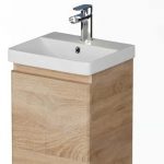 Wooden freestanding bathroom vanity with a white rectangular sink and chrome faucet.